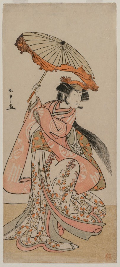Kabuki actor in salmon-pink layered robes with floral patterns holds a tilted orange parasol overhead, shown in profile against a plain ground.
