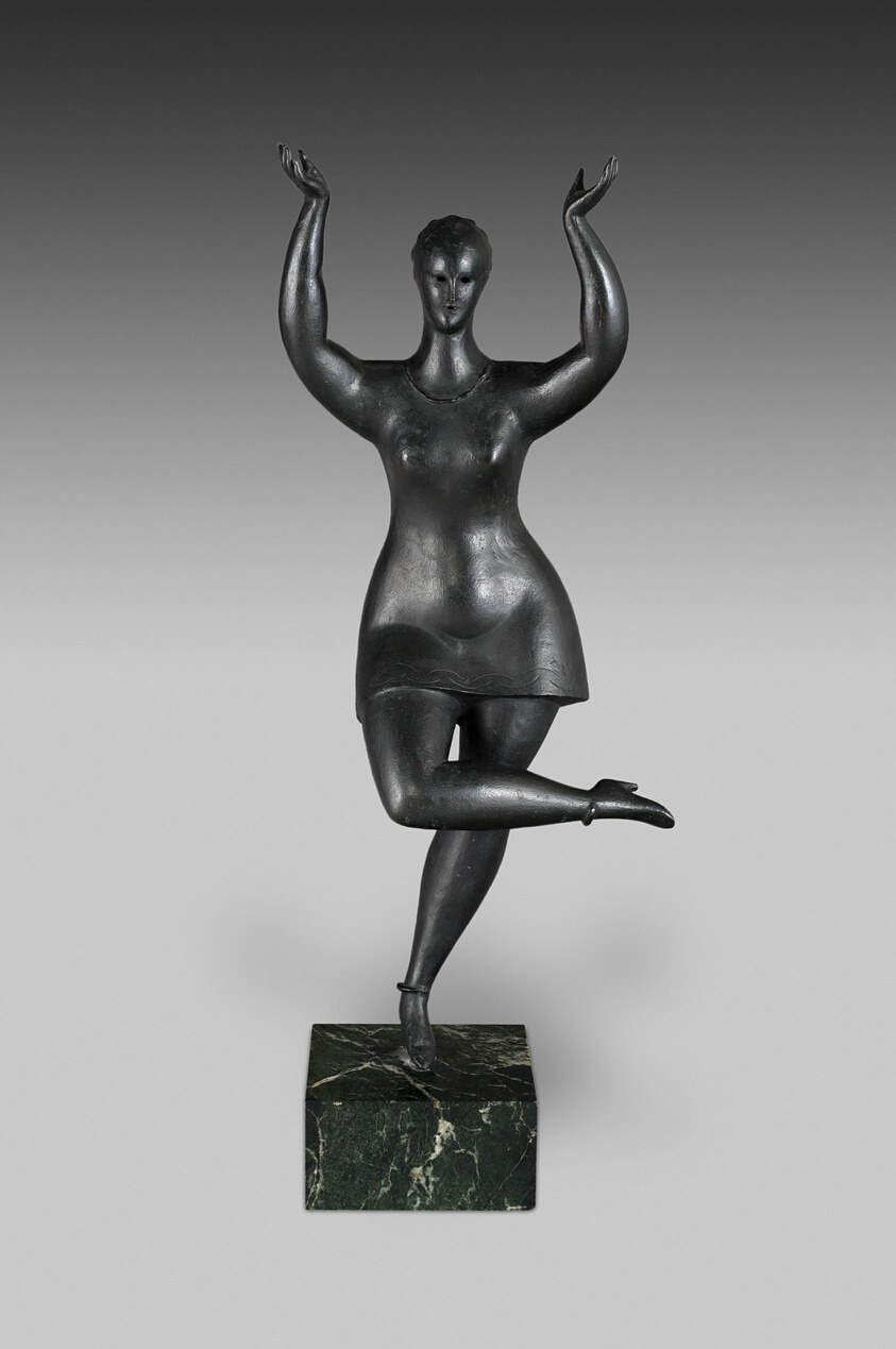 Bronze sculpture of a female figure with raised arms in a V-shape and one leg extended, on a marble base.