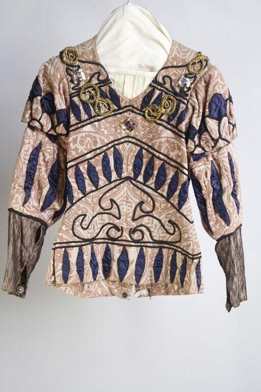 Sleeveless tunic with deep V-neck and draped hood, cream, tan and rust patterned with geometric leaf and diagonal line motifs, three-quarter ribbed sleeves.