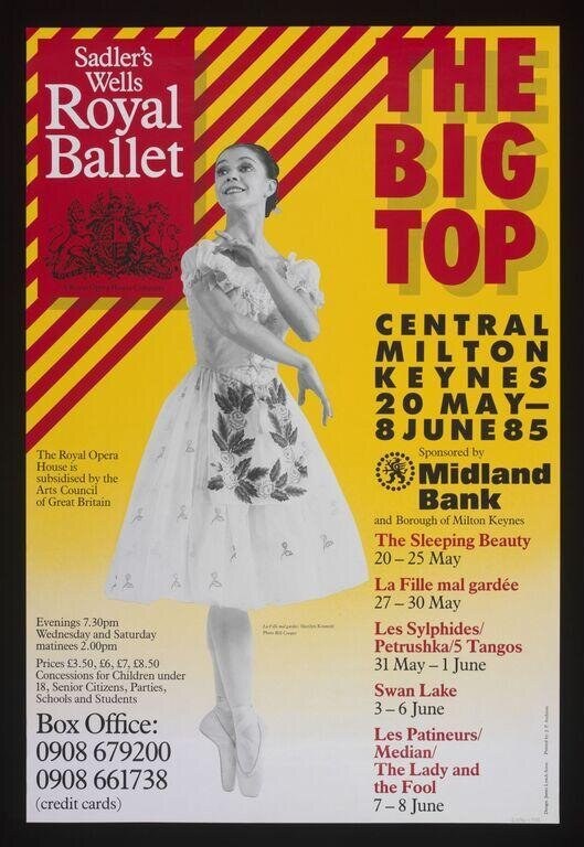 Female ballet dancer in pointe shoes and romantic tutu posed in arabesque against red and yellow diagonal stripes.