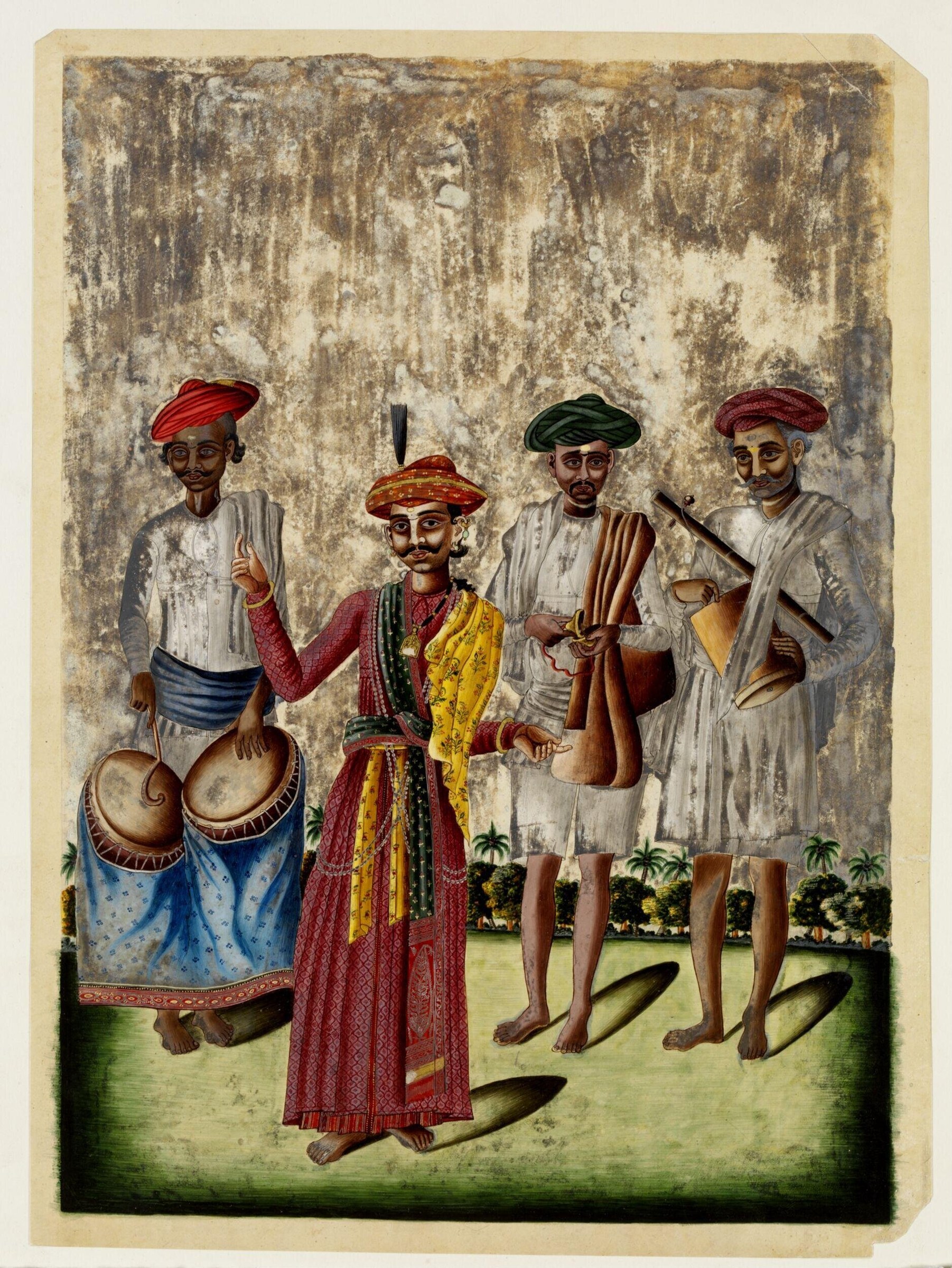 Five men in light garments stand before a weathered wall. The central figure wears an ornate red robe and turban; four others in white hold large hand drums.