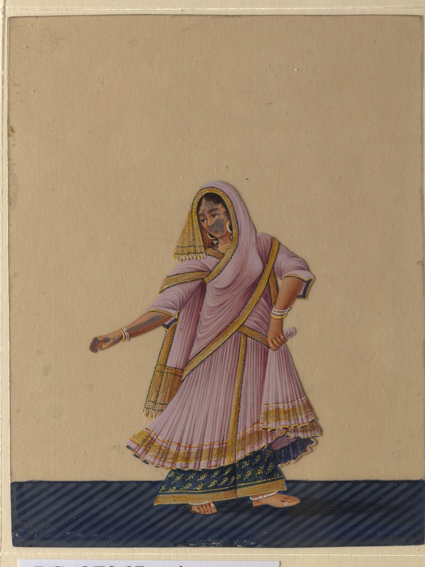 A woman in lavender draped dress with pleated skirt and gold-trimmed edges stands with weight shifted, one arm extended, wearing ankle bangles.