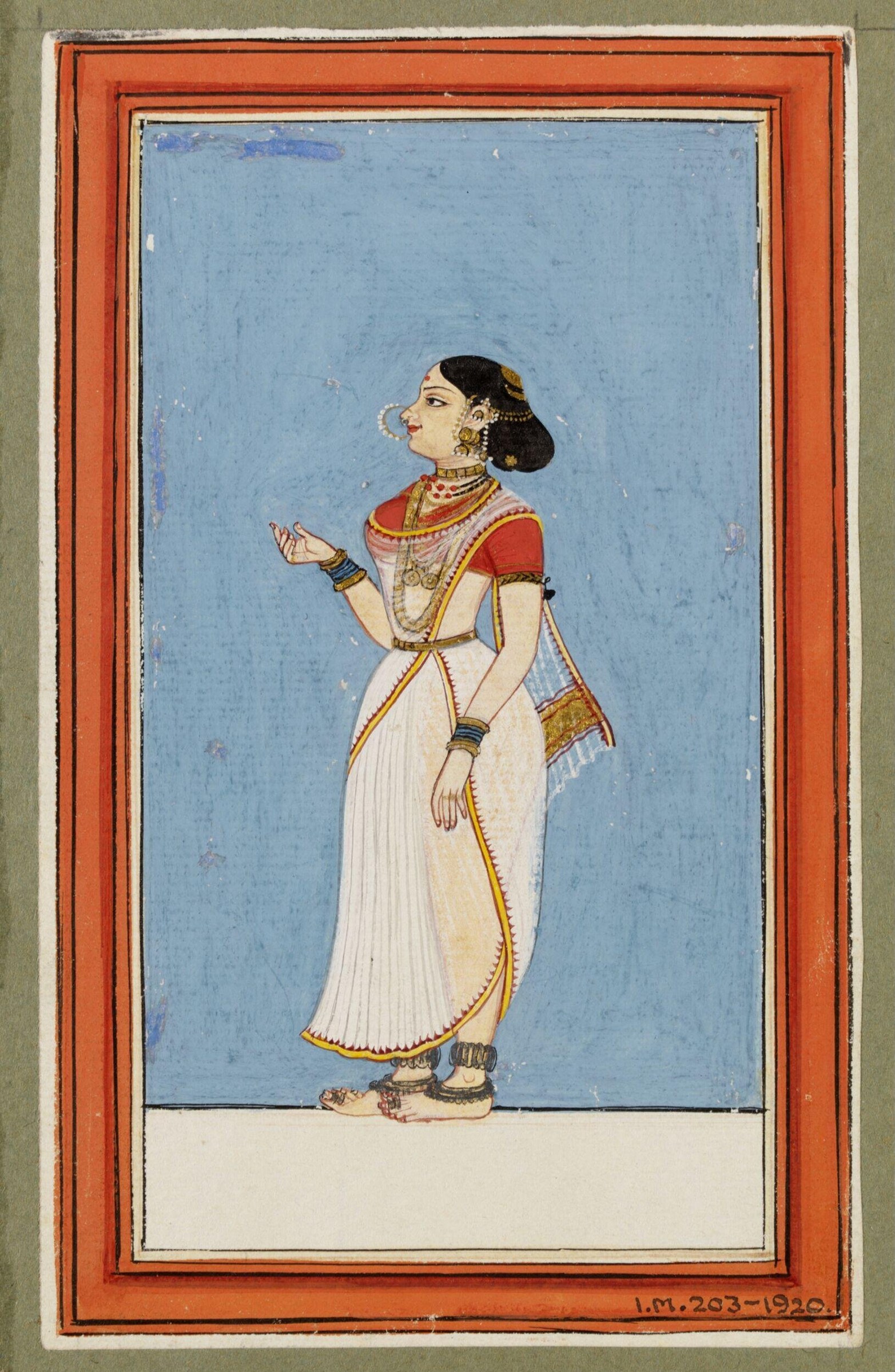 Woman in red blouse and pleated white skirt standing in profile against blue background, wearing gold jewelry and raising one hand in a gesture.