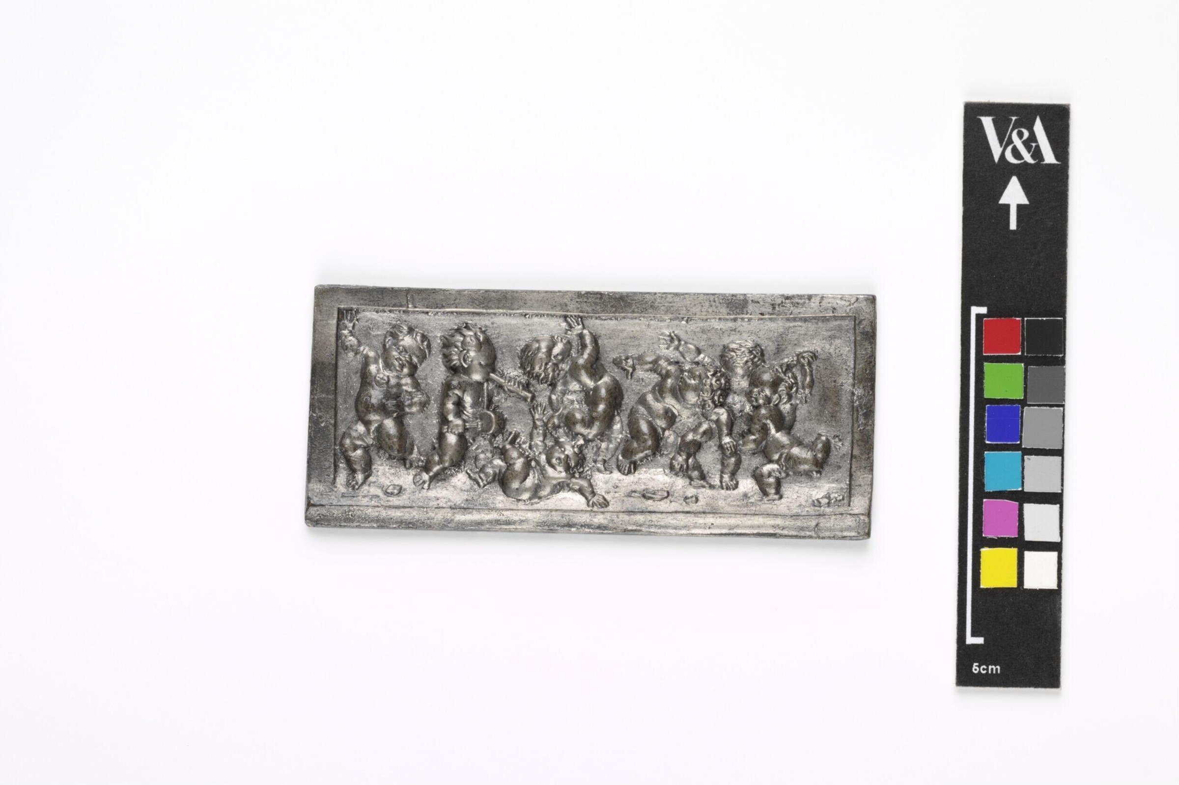 Cast metal relief plaque showing numerous winged cherubs in varied poses of animated movement and gesture against a recessed background.
