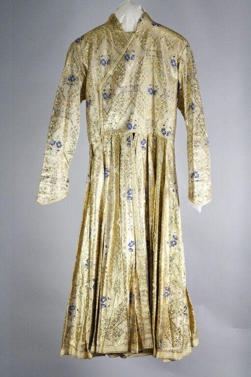 Cream silk day dress with blue floral print, fitted waist, and voluminous pleated skirt, displayed on a dress form.