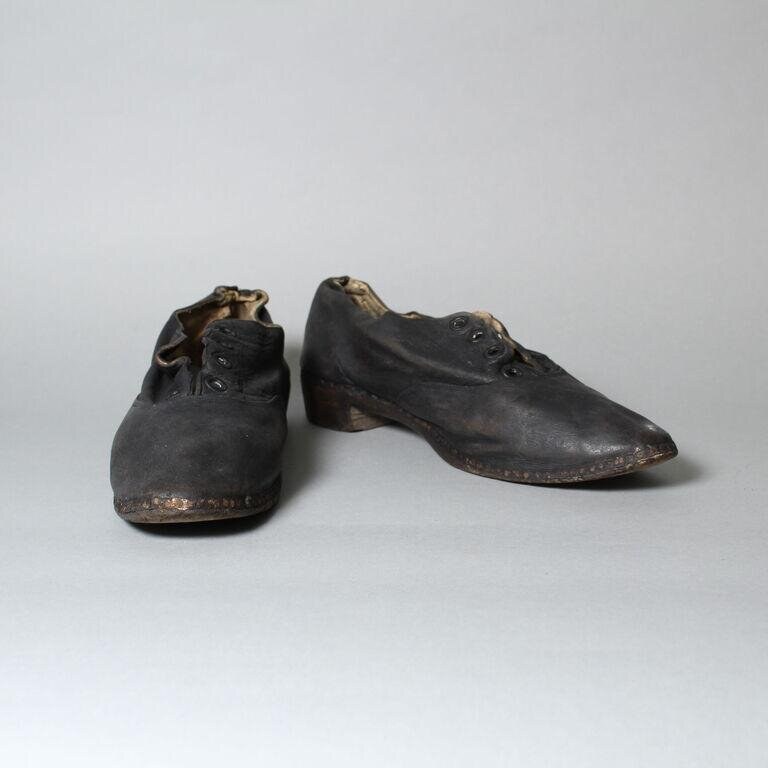 Pair of black leather heeled shoes with lacing, showing wear consistent with dance use circa 1920.