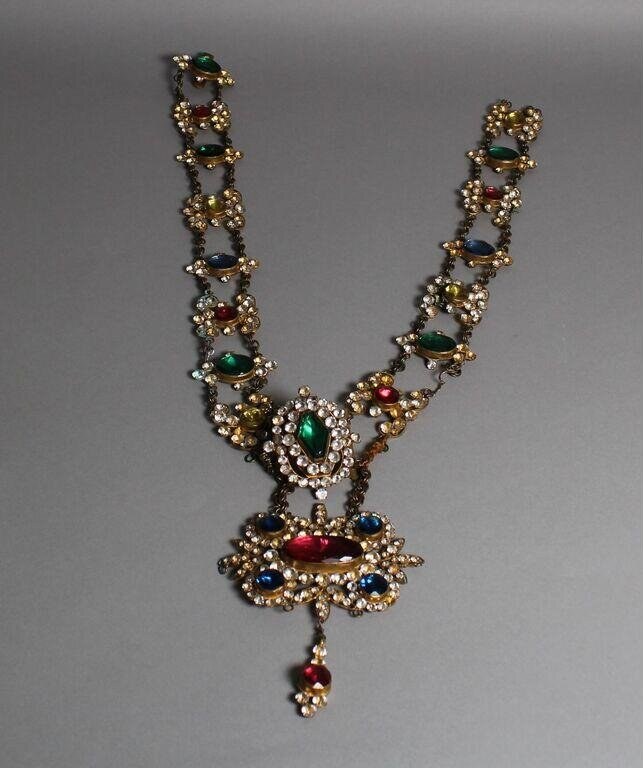 Jeweled U-shaped pendant necklace with emerald, sapphire, and ruby cabochons set in gold, featuring a large centerpiece and single pear-shaped drop.