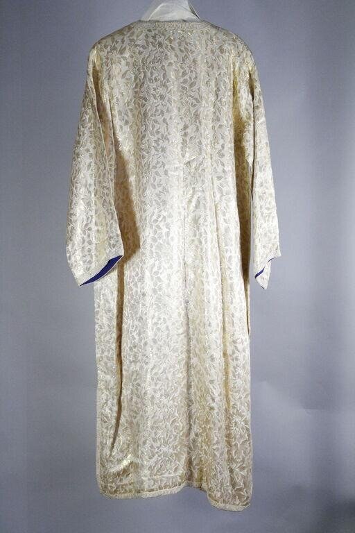 Pale cream damask robe with full sleeves and blue silk cuffs, displayed on a hanger against a neutral background.