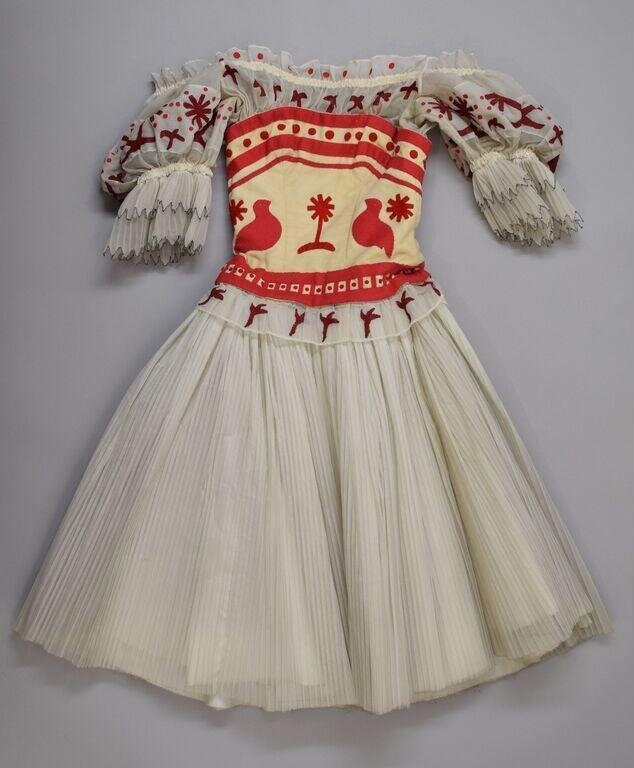 A cream linen folk dance costume: embroidered bodice with red puffed pleated sleeves and full pleated skirt.