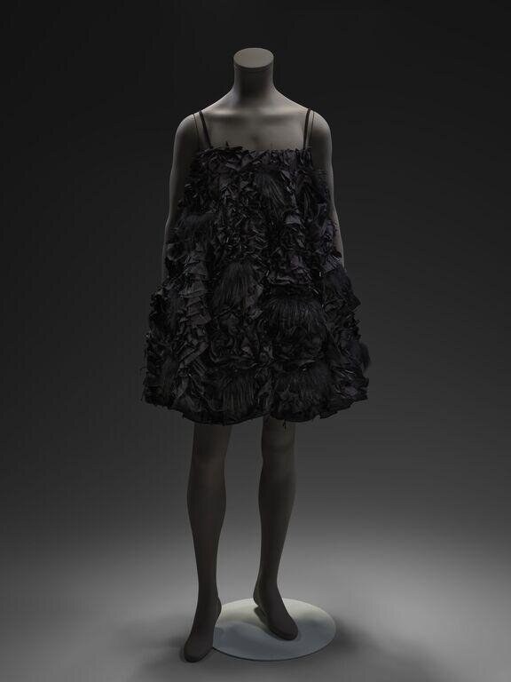 Black ruffled shift dress on a mannequin, studio photograph, front view