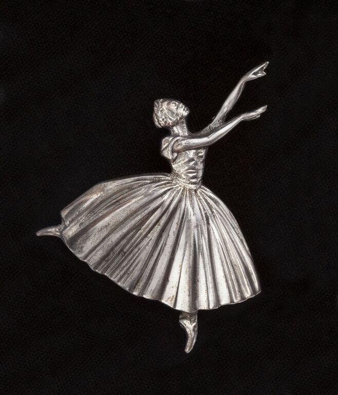 Silver brooch of a Romantic-era ballerina in a pointe attitude, with extended leg and lifted arms against her full tulle skirt.