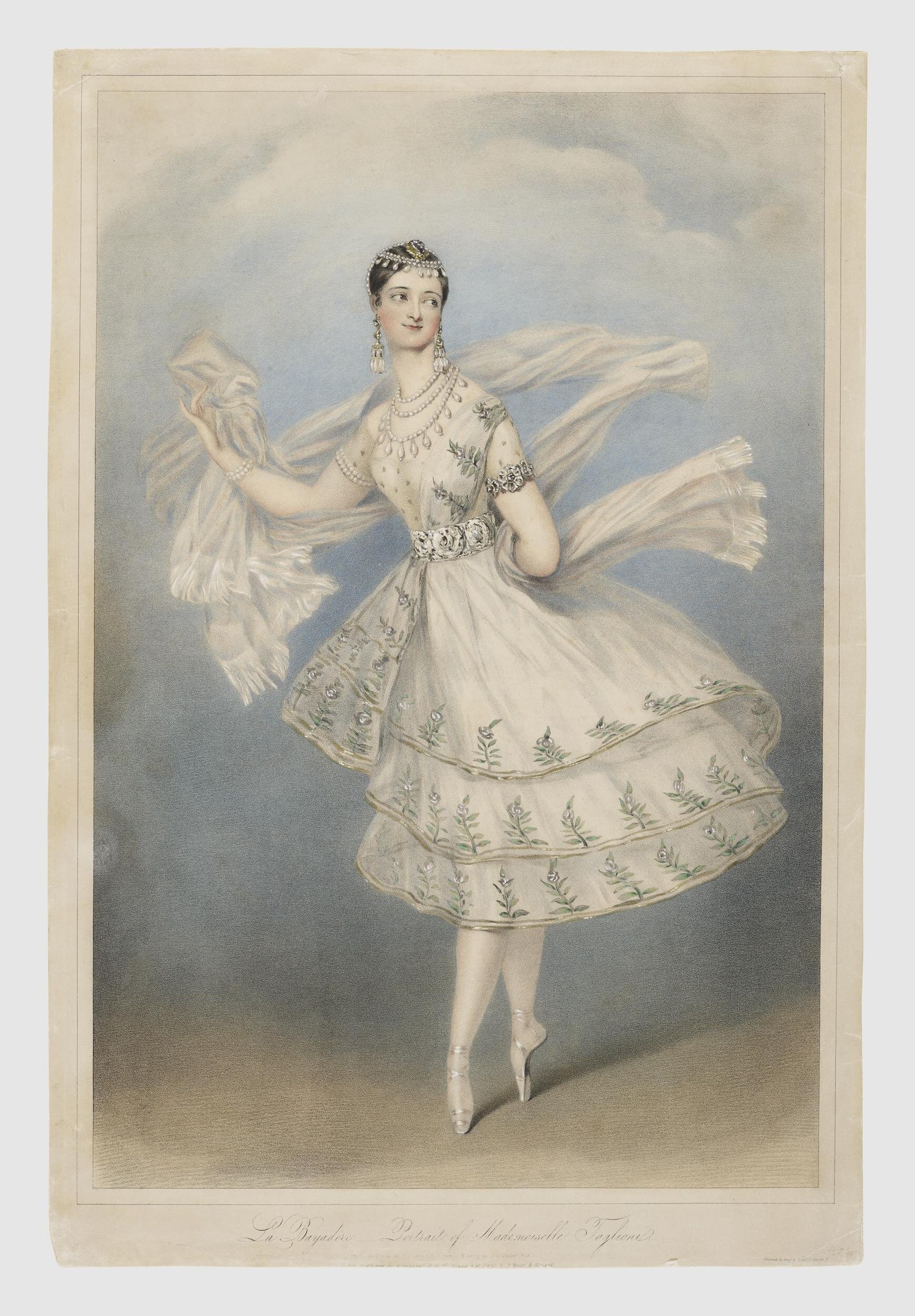 A woman in pale tulle and jewelry poses on pointe, arms raised, a billowing white shawl floating behind her against a clouded sky.