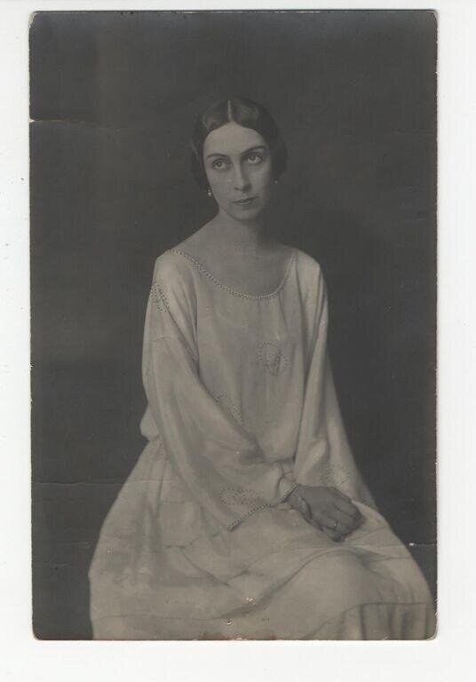 Studio portrait of a young woman in a pale embroidered chemise, seated and facing the camera, 1928.