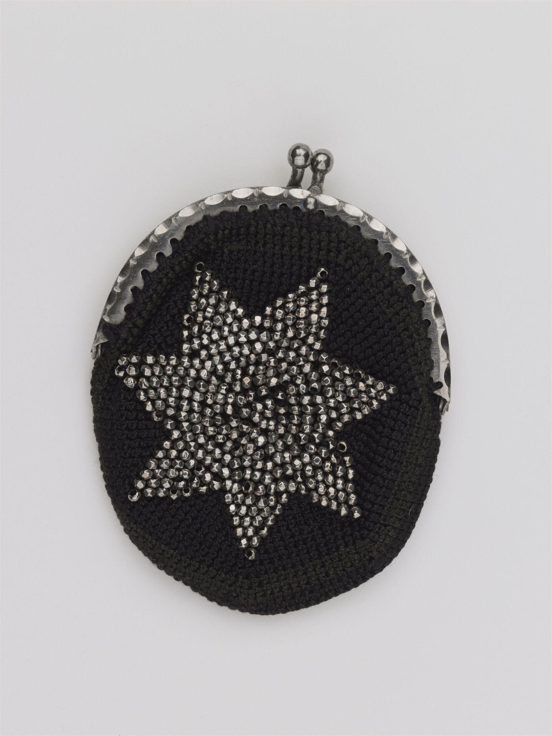 Black knitted evening purse with silver frame and five-pointed star of faceted metal beads, circa 1870.
