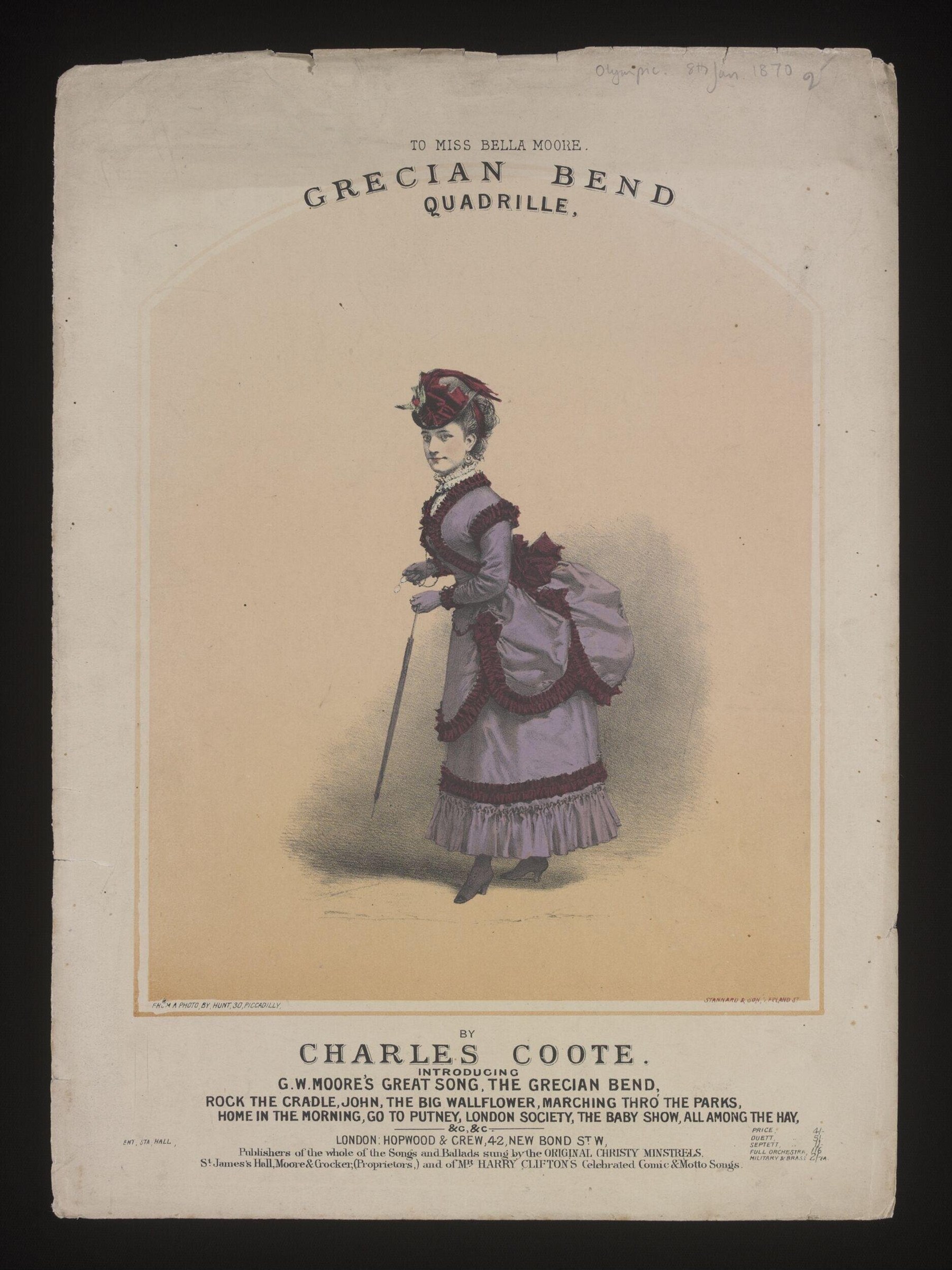 A woman in a lavender 1870s dress with bustle stands poised, leaning forward in the Grecian bend posture, holding a cane.