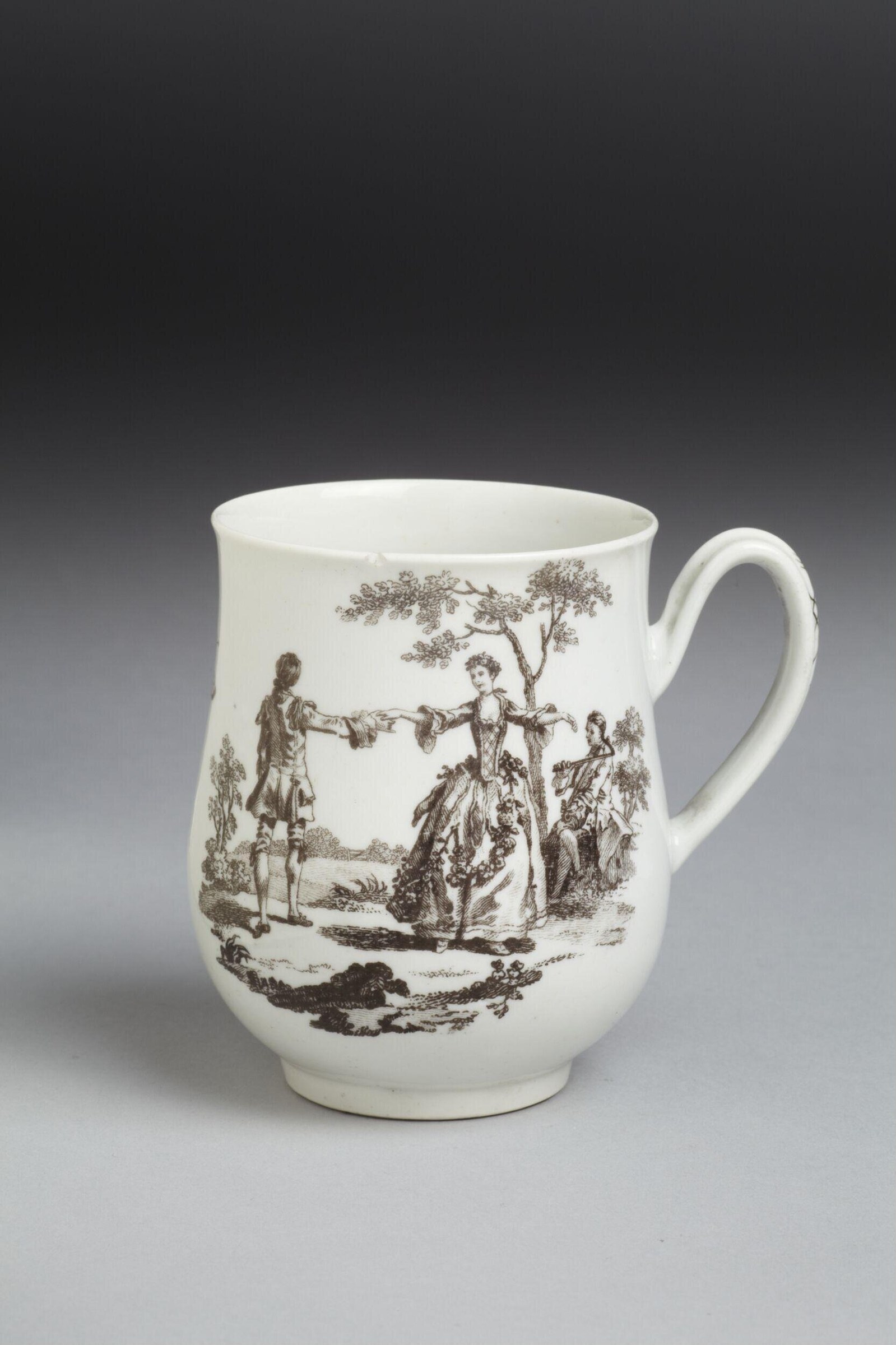 Sepia engraving on a ceramic mug: a woman in a pannered dress raises both arms toward a man in a coat, beneath a tree, as spectators watch.