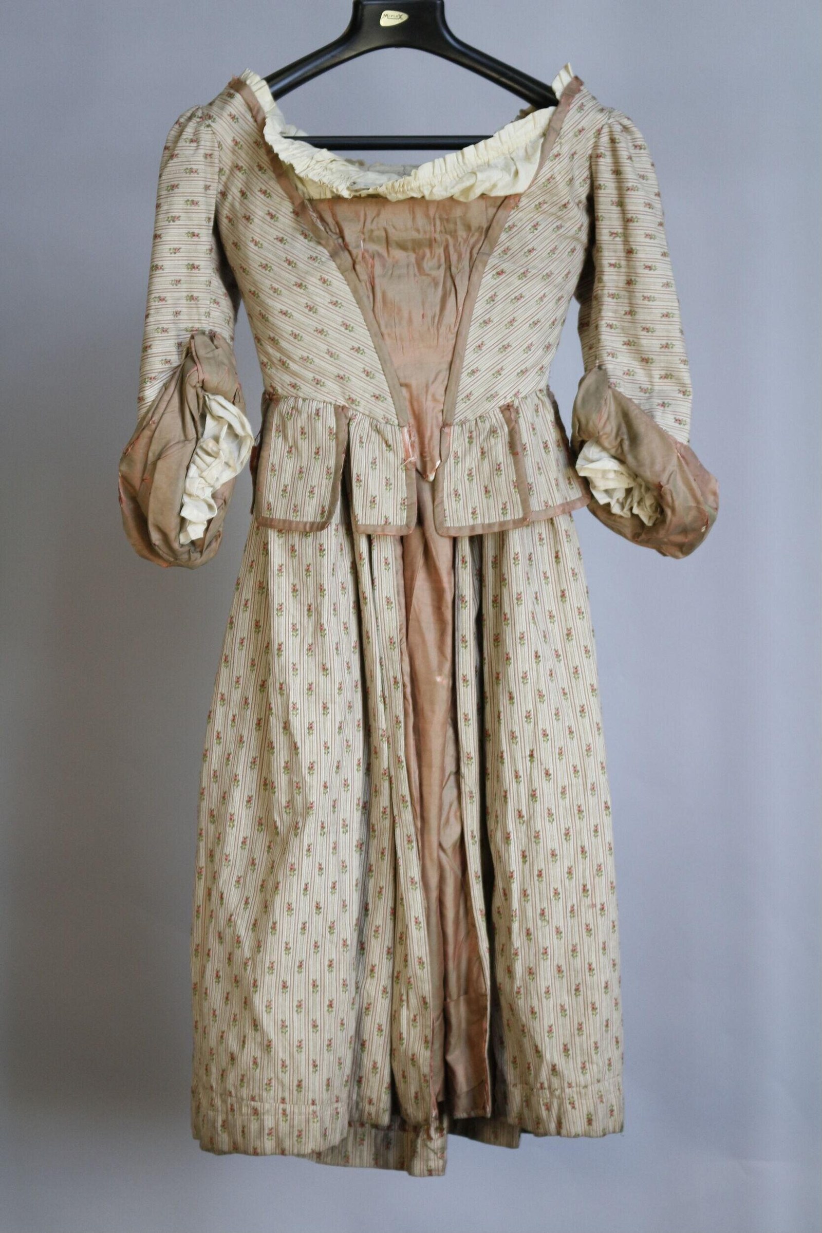 Early 1910s theatre costume: cream and brown printed cotton dress with peachy silk underlay, gathered skirt, and ruffled neckline and cuffs.