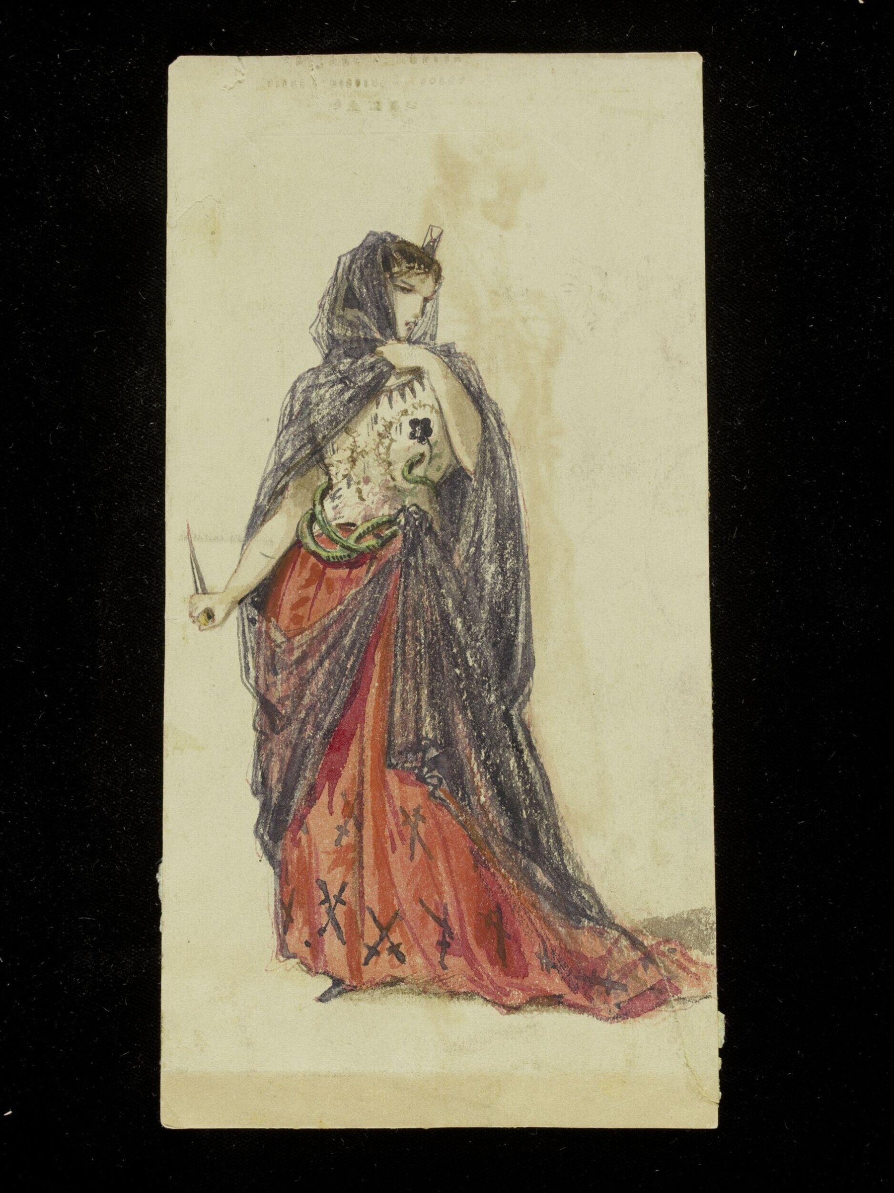 A standing woman in theatrical costume wearing a red skirt with black X-marks and a voluminous black lace veil, holding a dagger, against a plain background.