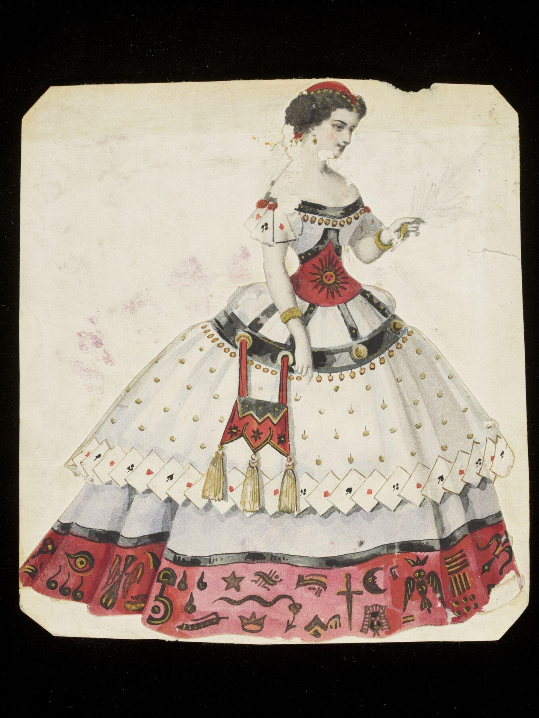 Standing woman in elaborate fancy-dress costume with white playing-card skirt, red underskirt with occult symbols, and ornate gold-trimmed jacket.