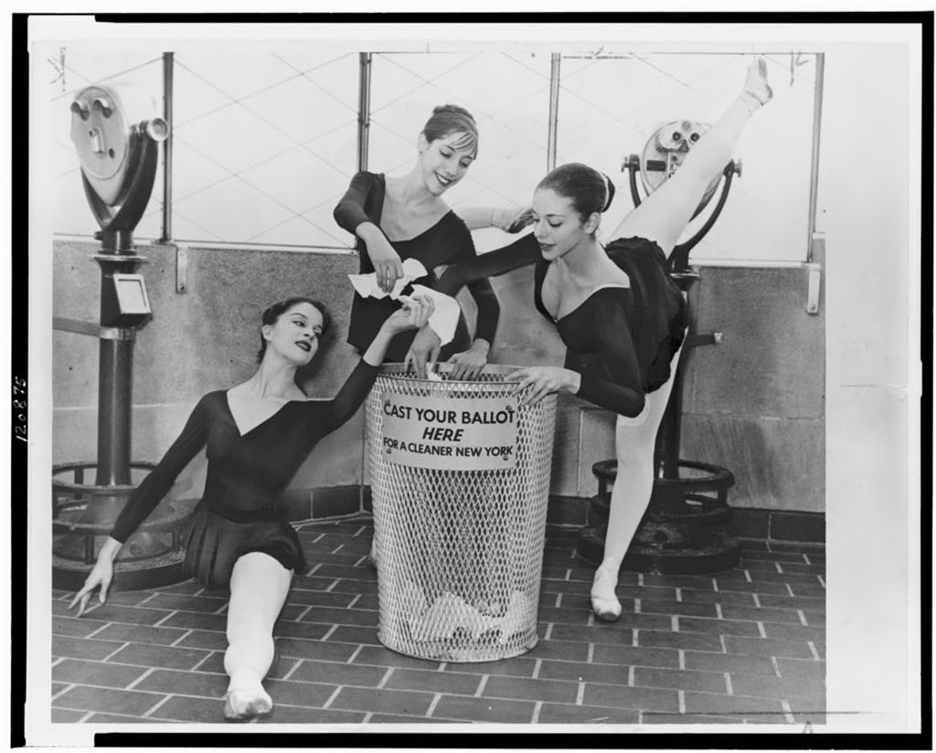 Four ballet dancers in pointe shoes and black leotards position themselves around a labeled ballot bin in a 1960s New York civic campaign photograph.