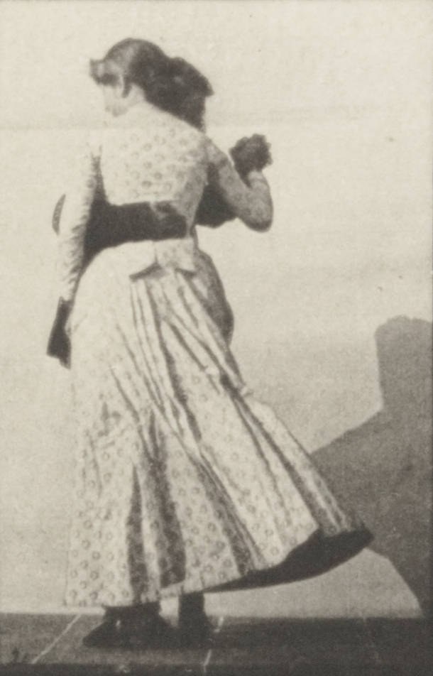 Woman in 1880s dress in closed ballroom frame, body tilted forward, left leg extended behind her, mid-waltz turn.