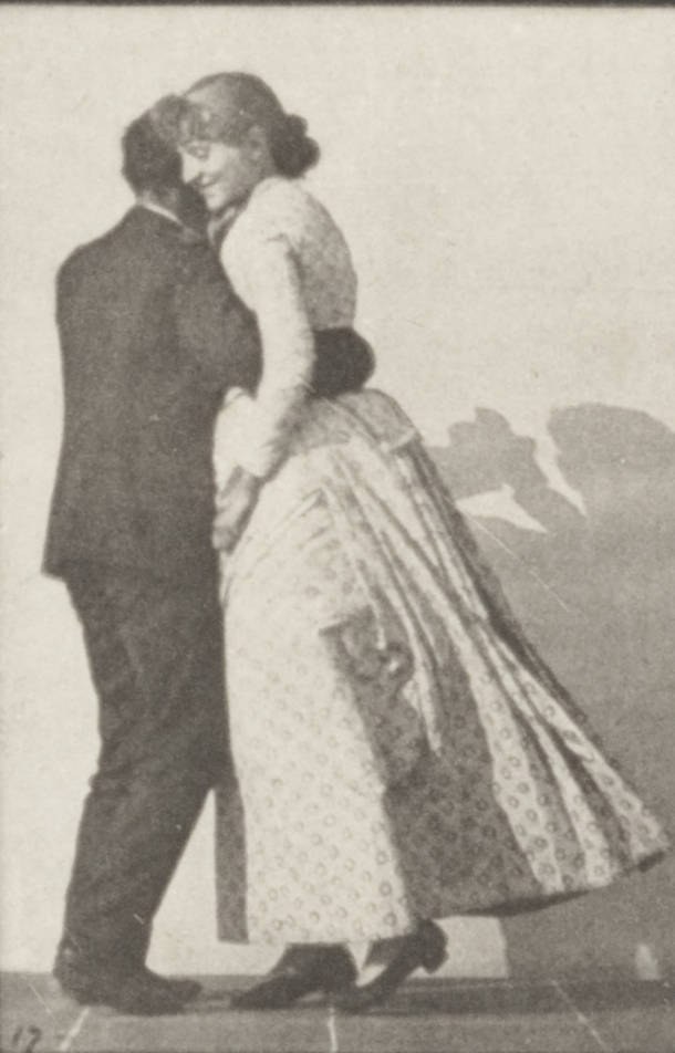 A man and woman in formal dress dance the waltz in a photogravure, the woman's skirt billowing from their rotation.