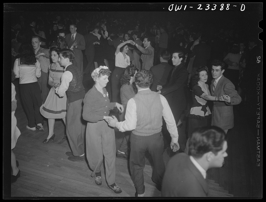 Overhead photograph of couples swing dancing in a crowded ballroom, captured in black and white during the early 1940s.
